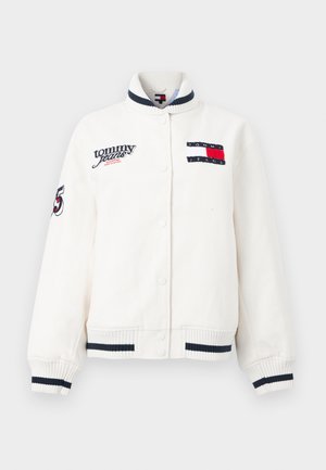 White button-up jacket with ribbed cuffs and collar featuring navy stripes, Tommy Jeans logo patches, and number 85 embroidery on sleeve.