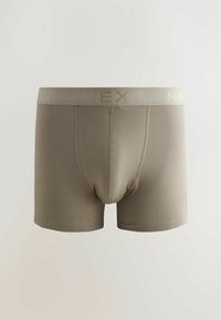 Bañadores de boxeador beige hechos de una tela suave y elástica. Cuentan con una cinturilla con el logo y la inscripción "NEXT". Piernas de longitud media, sin patrones adicionales.