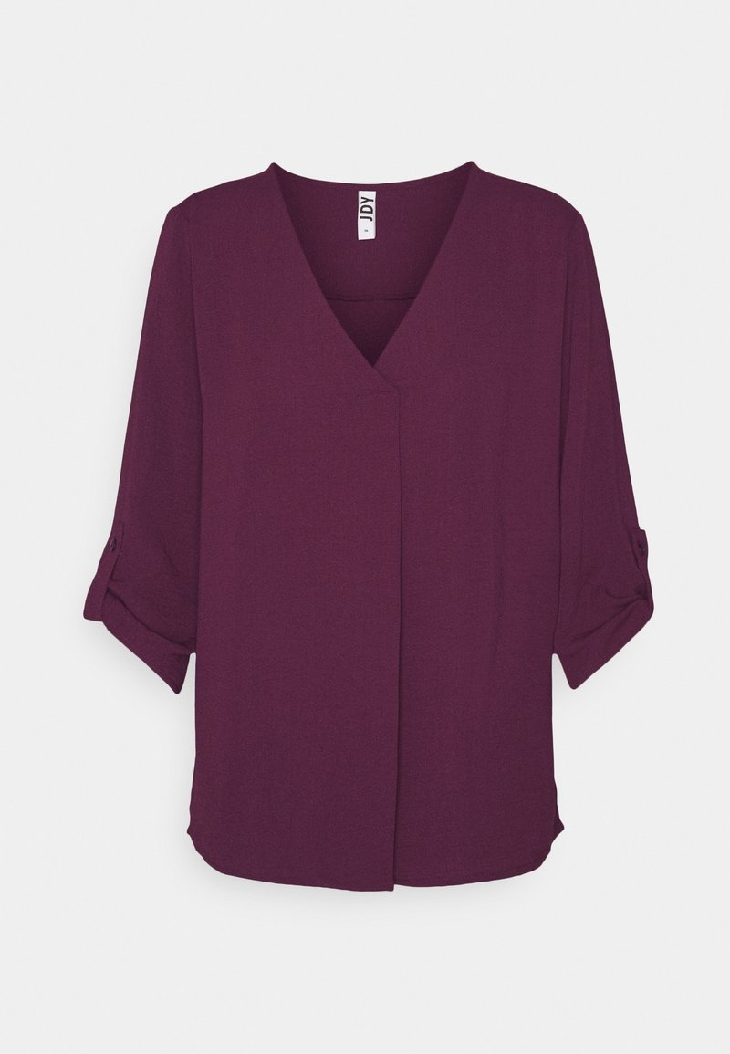 Blouse violet foncé à col en V avec manches trois-quarts retroussées et boutonnées, design simple, sans motifs ni décorations visibles.