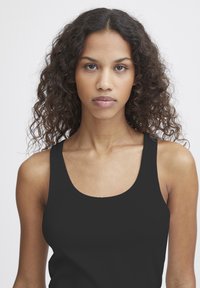 Zwarte geribbelde tanktop met brede bandjes, een getailleerde silhoette en een gladde, zachte textuur. Eenvoudig ontwerp zonder patronen of extra details.