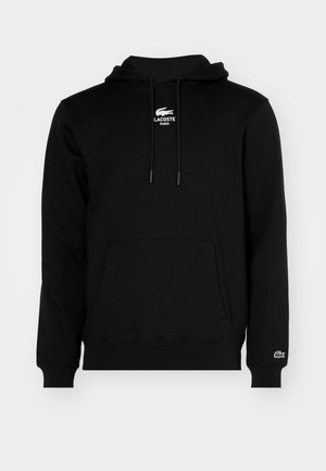 Zwarte capuchontrui met voorzak (kangoeroezak), trekkoorden en wit Lacoste-logo met de tekst "LACOSTE PARIS" op borst en mouw.