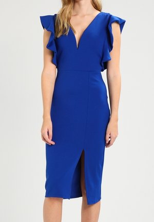 Królewsko niebieska sukienka midi bez rękawów z głębokim dekoltem w serek, zdobiona falbanami na ramionach oraz rozcięciem z przodu, noszona przez kobietę na jednolitym tle.