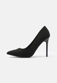 Černá lodička na vysokém podpatku z semiše s špičatou špičkou a elegantním designem. Disponuje lesklým černým jehlovým podpatkem.