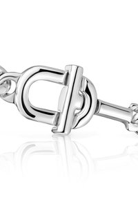 Pulsera de cadena de plata que presenta un diseño de cierre distintivo con superficies lisas y pulidas, y un acabado reflectante.