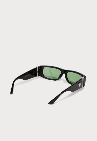 Fekete téglalap alakú napszemüveg zöld lencsékkel. Ezüst színű kiegészítők és logó részlet a szárán. Sleek tervezés és sima textúra.