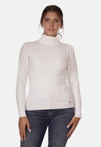 Maglione bianco a collo alto con texture a coste, maniche lunghe e design aderente. Presenta un piccolo accento con il marchio vicino all'orlo.