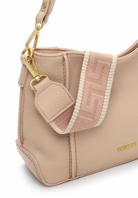 Pehme roosa nahast käekott tekstuurse viimistlusega, millel on mustriline kangast rihm, kuldsed detailid ja küljele pressitud brändilogo.