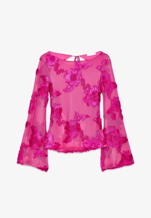 Blusa trasparente rosa con maniche lunghe a campana, caratterizzata da ricami floreali in rilievo in diverse tonalità di rosa. Dettaglio a chiave sul retro.