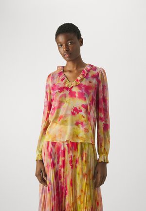 Blusa a maniche lunghe in tessuto leggero e trasparente con un motivo floreale colorato in rosa e giallo, con dettagli di colletto arruffato e polsini.