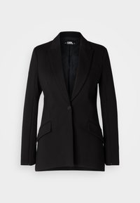 Blazer negro de tela lisa, con solapa con muesca, cierre de un botón, dos bolsillos frontales y mangas largas ajustadas.