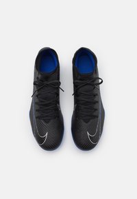 Scarpe da ginnastica nere con tomaia testurizzata, soletti blu e lacci neri. Presentano un logo Nike bianco e motivi lineari sottili sulla superficie.