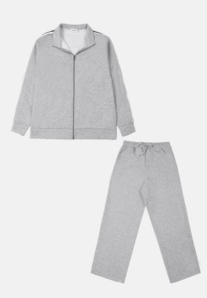 Veste grise zippée avec un col montant, rayures latérales contrastées ; pantalon assorti à taille élastique avec une coupe décontractée et des jambes droites.