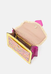 Farverig håndtaske med en lyserød læderoverflade, en tekstureret gul klap med et multikolor mønster og et kontrastfyldt beige interiør.