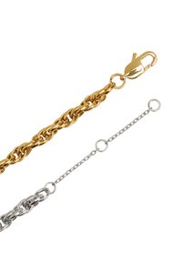 Złoty i srebrny naszyjnik łańcuszkowy z dużym zapięciem w kształcie homara i delikatnymi akcentami łańcuszka, prezentujący fakturowane wykończenie i warstwowy design.