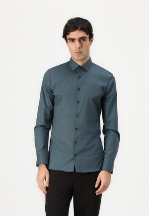 Long-sleeve button-up shirt in dark teal fabric with a textured pattern, featuring a pointed collar and black buttons down the front.