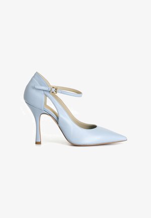 Zapato de tacón alto de cuero azul claro con punta puntiaguda, correa en el tobillo y hebilla dorada sobre fondo blanco.