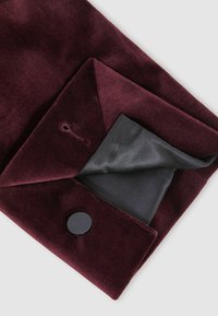 Colletto in velluto bordeaux con foderatura in raso nero, dotato di un bottone nero rotondo e di un piccolo foro decorativo.