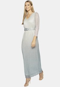 Maxi sukienka w gradientzie srebra i jasnego niebieskiego z pionowymi paskami, dekoltem w kształcie litery V, rękawami do trzech ćwiartek oraz akcentem w postaci zawiązywanego pasa.