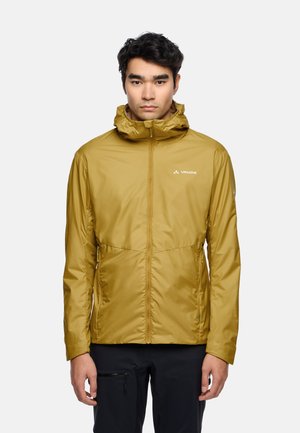 Giacca leggera giallo-marrone con cappuccio, chiusura con cerniera frontale, due tasche laterali e un logo sul petto. Tessuto liscio e resistente all'acqua.