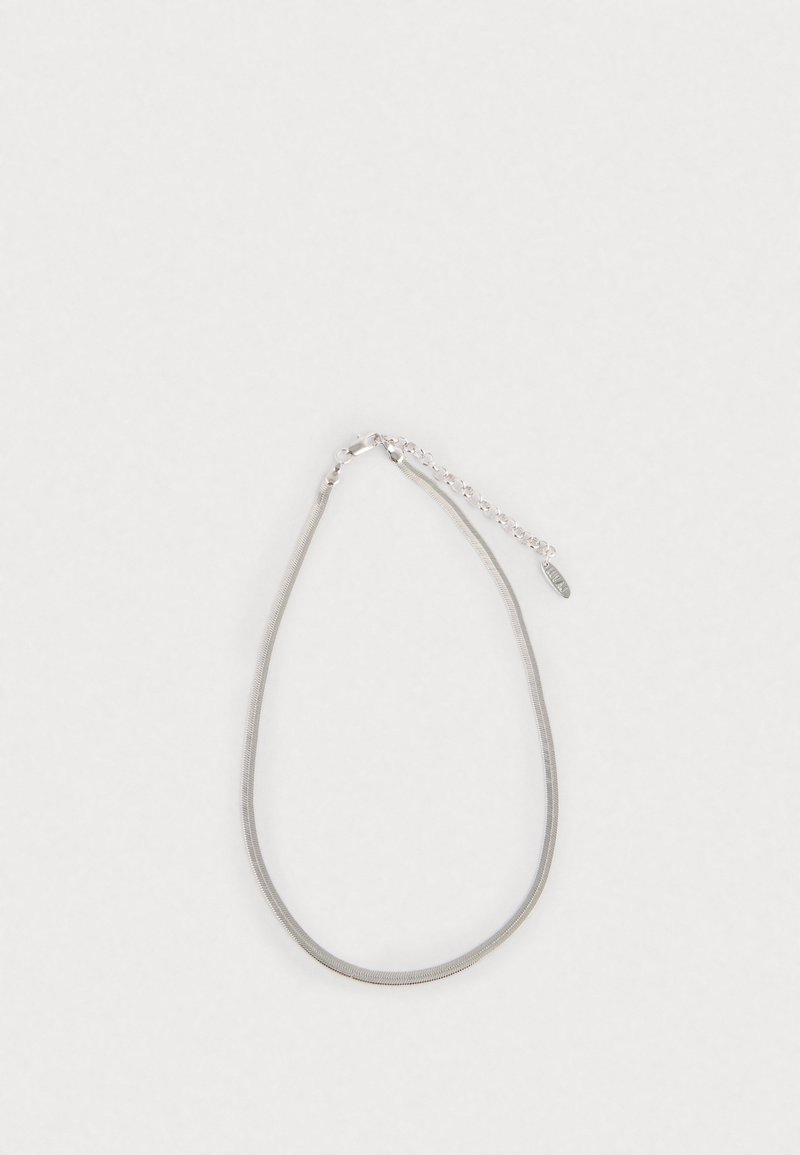 Grijze metalen ketting met een gladde textuur, voorzien van een verstelbare sluiting en een klein label nabij de sluiting. Eenvoudig, minimalistisch ontwerp.