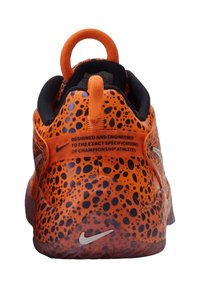Scarpa da ginnastica arancione con un design texture maculato, caratterizzata da un interno nero, una conspicua ansa sul tallone e il logo Nike metallico sul lato.