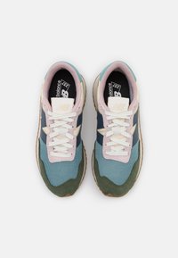 Blå, gröna och rosa New Balance-sneakers med överdel i mesh och mocka. Har vita snören, vadderad krage och brun gummisula.