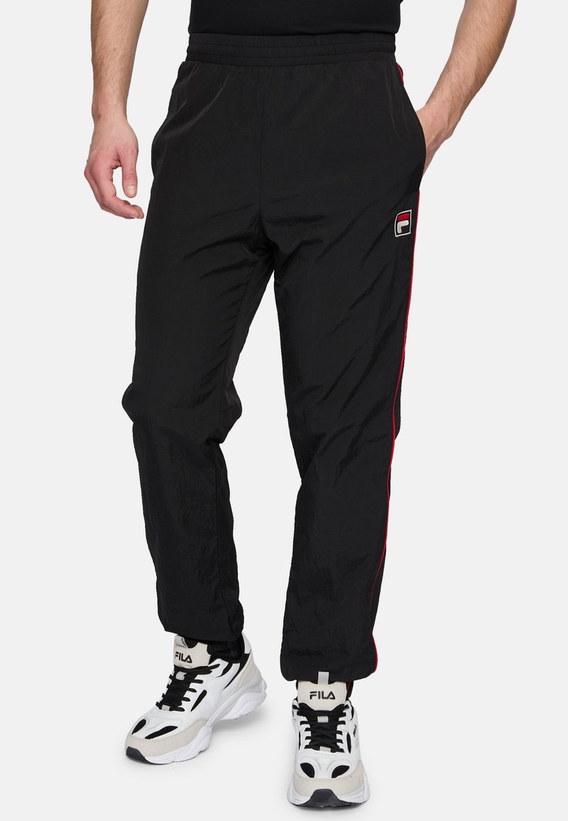 Zwarte trainingsbroeken van lichtgewicht materiaal, met rode zijstrepen en een geborduurd logo. De tailleband is elastisch voor comfort.