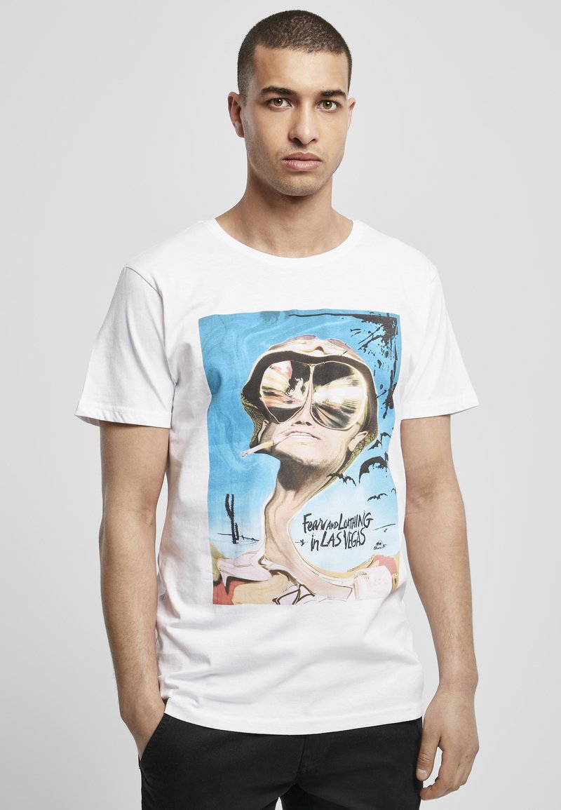 T-shirt en coton blanc avec un imprimé graphique coloré représentant une figure déformée portant des lunettes de soleil, accompagnée du texte "Fear and Loathing in Las Vegas."