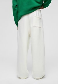 Witte katoenen sweatpants met een losse pasvorm, voorzien van een elastische tailleband en een enkele achterzak. Soepele textuur met een casual ontwerp.