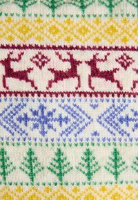 Strickstoff mit mehrfarbigen Mustern: rote Rentiere, blaue geometrische Formen, grüne Bäume und gelbe Rauten auf einem cremefarbenen Hintergrund.