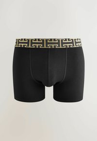 Boxeri negri cu un elastic la talie cu un model aurie și negru. Material neted, formă ajustată și lungime până la mijlocul coapsei.