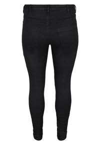 Black denim skinny jeans with a mid-rise waist, featuring two back pockets and a smooth texture. No visible hardware or embellishments.
