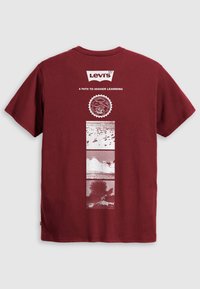 Burgundi Levi's póló "Egy út a magasabb tanuláshoz" felirattal, San Francisco pecséttel és három függőleges téglalap alakú természetfotóval fehér nyomtatással.