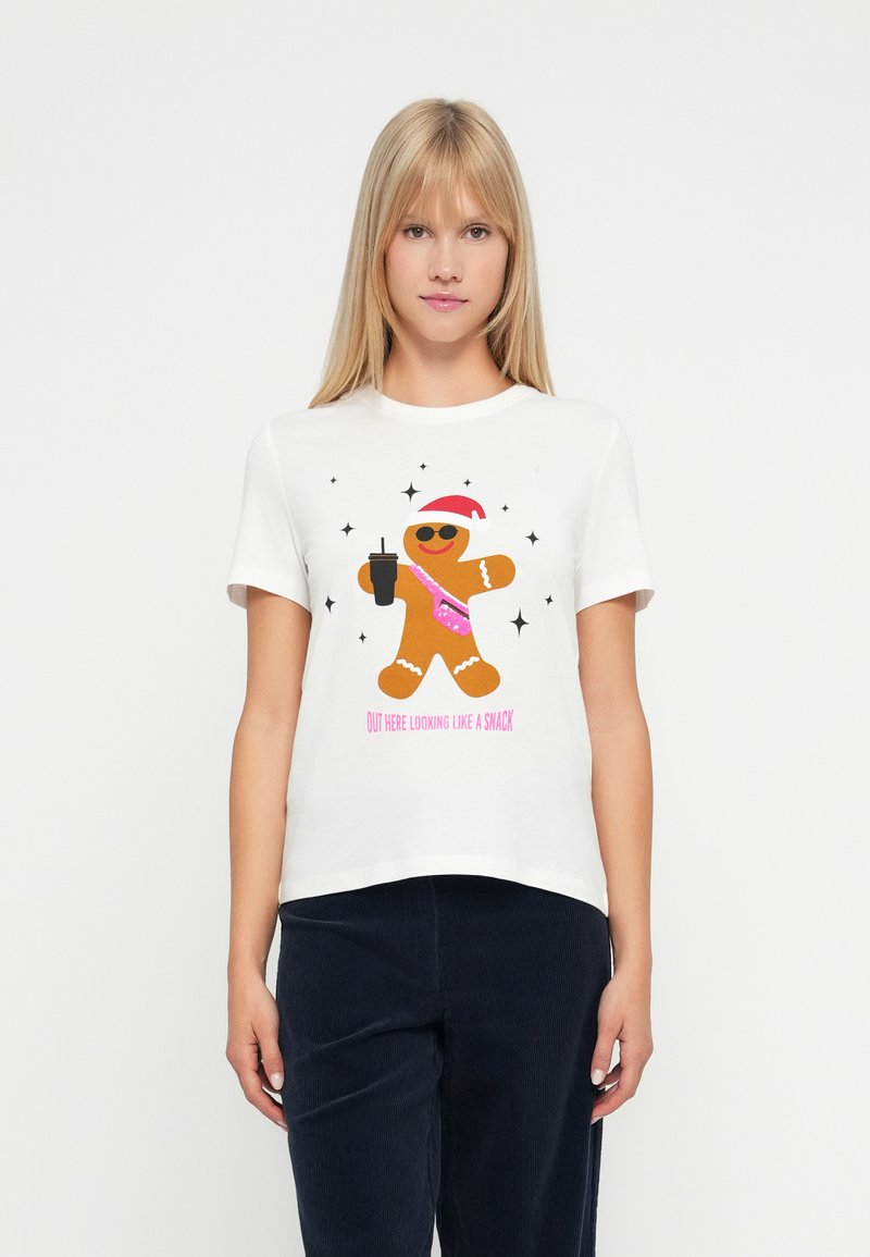 Γυναίκα που φοράει ένα λευκό t-shirt με γραφικό ενός μπισκότου τζίντζερ που κρατάει ένα ποτό, φοράει γυαλιά ηλίου και χριστουγεννιάτικο καπέλο, με το κείμενο "Φαίνομαι Σα να Είμαι Σνακ."