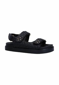 Zwarte gewatteerde leren sandaal met twee verstelbare klittenbandsluitingen en decoratieve studs. Platte zwarte zool met een gladde textuur.