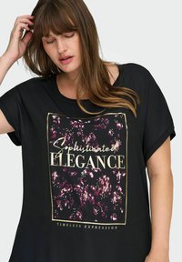 Must have lühikesed varrukad T-särk musta värviga, millel on lilla ja kuldne lilleline grafika koos tekstiga "Peen Elegants" ja "Ajatu Väljendus."