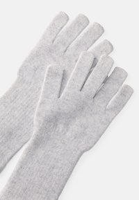 Γκρίζα πλεκτά γάντια με ξεχωριστά δάχτυλα, κατασκευασμένα από μαλακό με υφή ύφασμα. Κλασικός σχεδιασμός, κατάλληλος για χρήση σε κρύο καιρό.