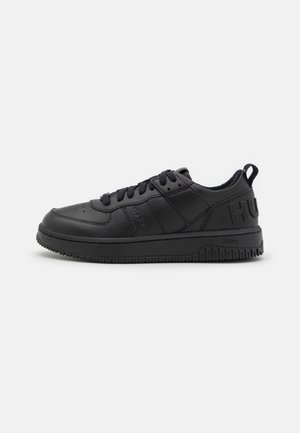 Sort lavtop sneakers med snørelukning foran, polstret krave, tekstureret sål og præget branding på siden og hælen.