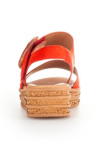 Oranje suède sandaal met brede banden, ronde accent en platformzool van textuurkurk. Ontwerp met open achterkant voor ademend vermogen.