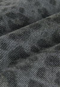 Gray woven fabric with a textured surface, featuring a subtle striped pattern. The material appears soft and flexible, suitable for clothing.