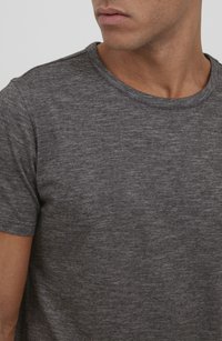 Camiseta gris de manga corta con escote redondo, hecha de tela texturizada que presenta un sutil patrón jaspeado.