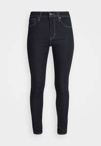 Vaqueros skinny azul oscuro de mezclilla, con cintura alta, pasadores para cinturón, bolsillos delanteros y costuras en contraste.