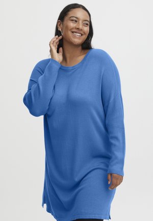 Niebieski, oversize sweter wykonany z miękkiej dzianiny, posiadający okrągły dekolt, długie rękawy i boczne rozcięcia na dole. Casualowy, luźny krój.