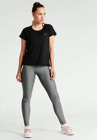 Svart T-skjorte med korte ermer i atletisk stil, tilpassede grå leggings med teksturert mønster, og lyserosa treningssko. Enkelt design, funksjonell stil.