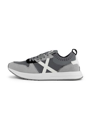 Zapatillas grises que combinan materiales de malla y ante, con un diseño de cruz blanca, acentos negros y un cuello texturizado. Suela de goma.