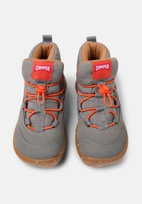 Szare wysokie buty sportowe z pomarańczowymi sznurowadłami, gumową podeszwą i wyściółką w kolorze beżowym. Posiadają czerwoną metkę z logo "CAMPER".