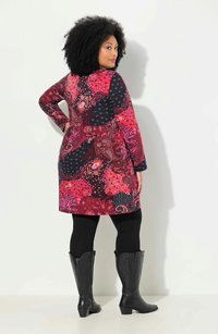 Kortärmad knälång klänning i rosa och marinblått med blommiga och paisleymönster, matchad med svarta leggings och svarta stövlar med spetsig tå.