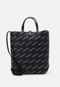 Svart tygväska med upprepad "Tommy Jeans"-tryck, tillverkad av texturerad nylon och med två ovandelar samt en avtagbar axelrem.