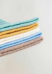 Stack of folded knitted fabric pieces in teal, mustard, white, light blue, and beige on a light surface.