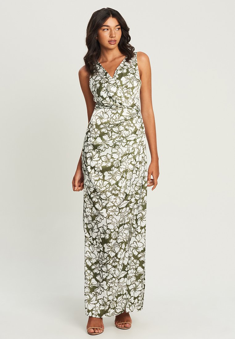 Maxi dress in white with green floral pattern, featuring a v-neck, sleeveless design, and a fitted waist that flows to a floor-length hem.